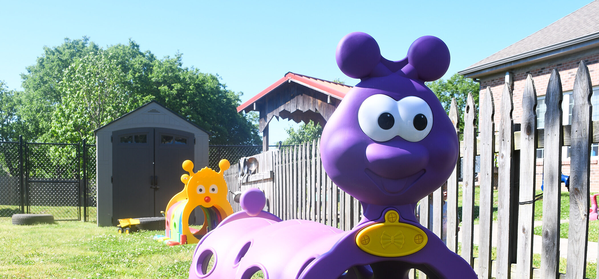 Purple and yellow playground climbing creatures sit in a playground.