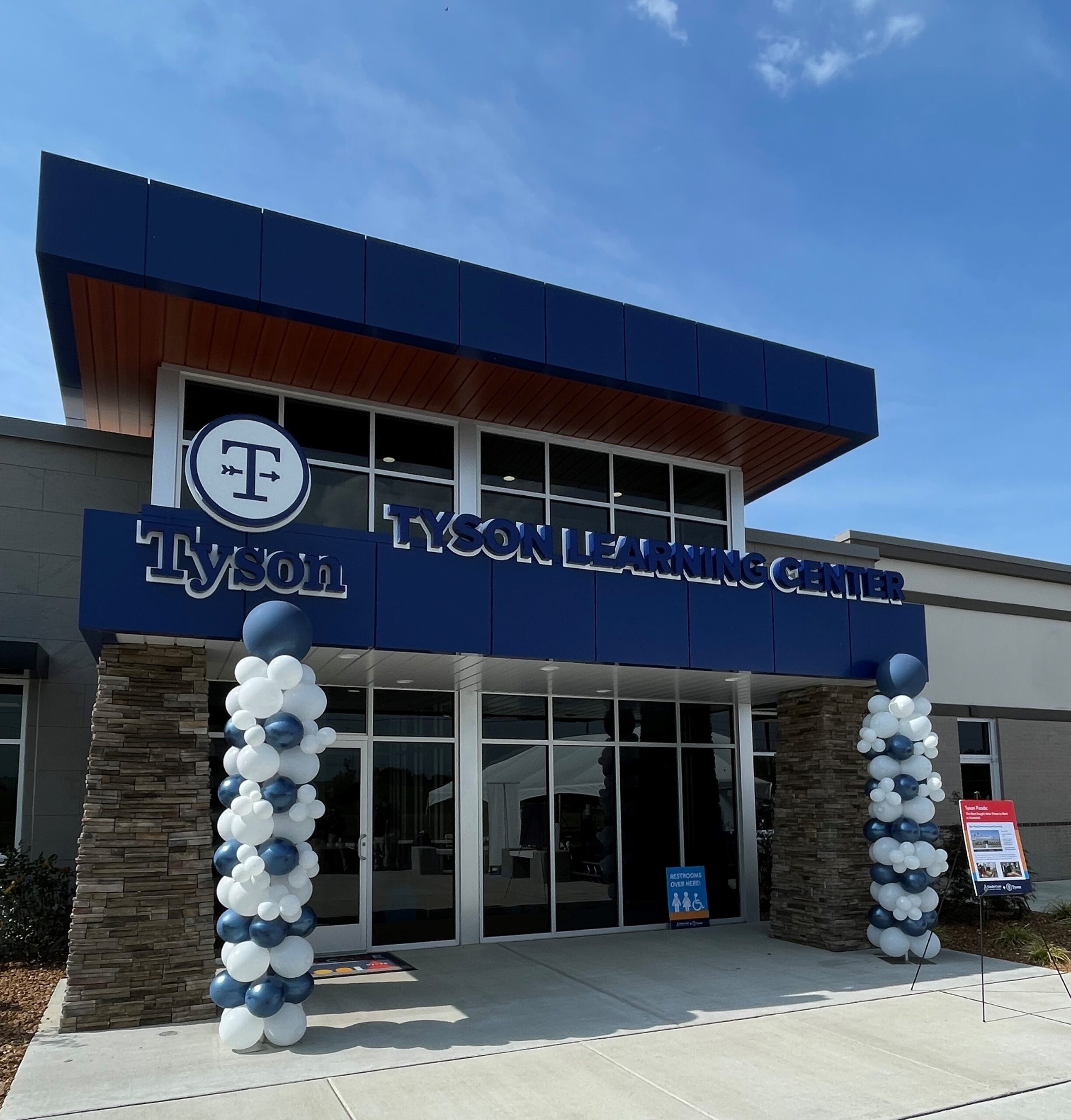 Grand opening of the Tyson Early Learning Center in Humboldt, TN. The building is blue and gray with blue and white balloons at the entrance.