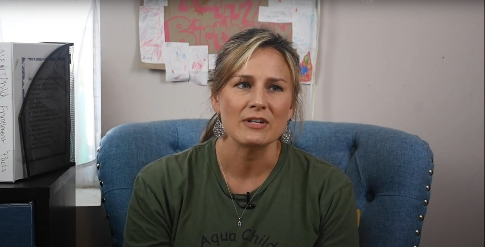 A white, middle-aged child care director sits in a chair and is interviewed.