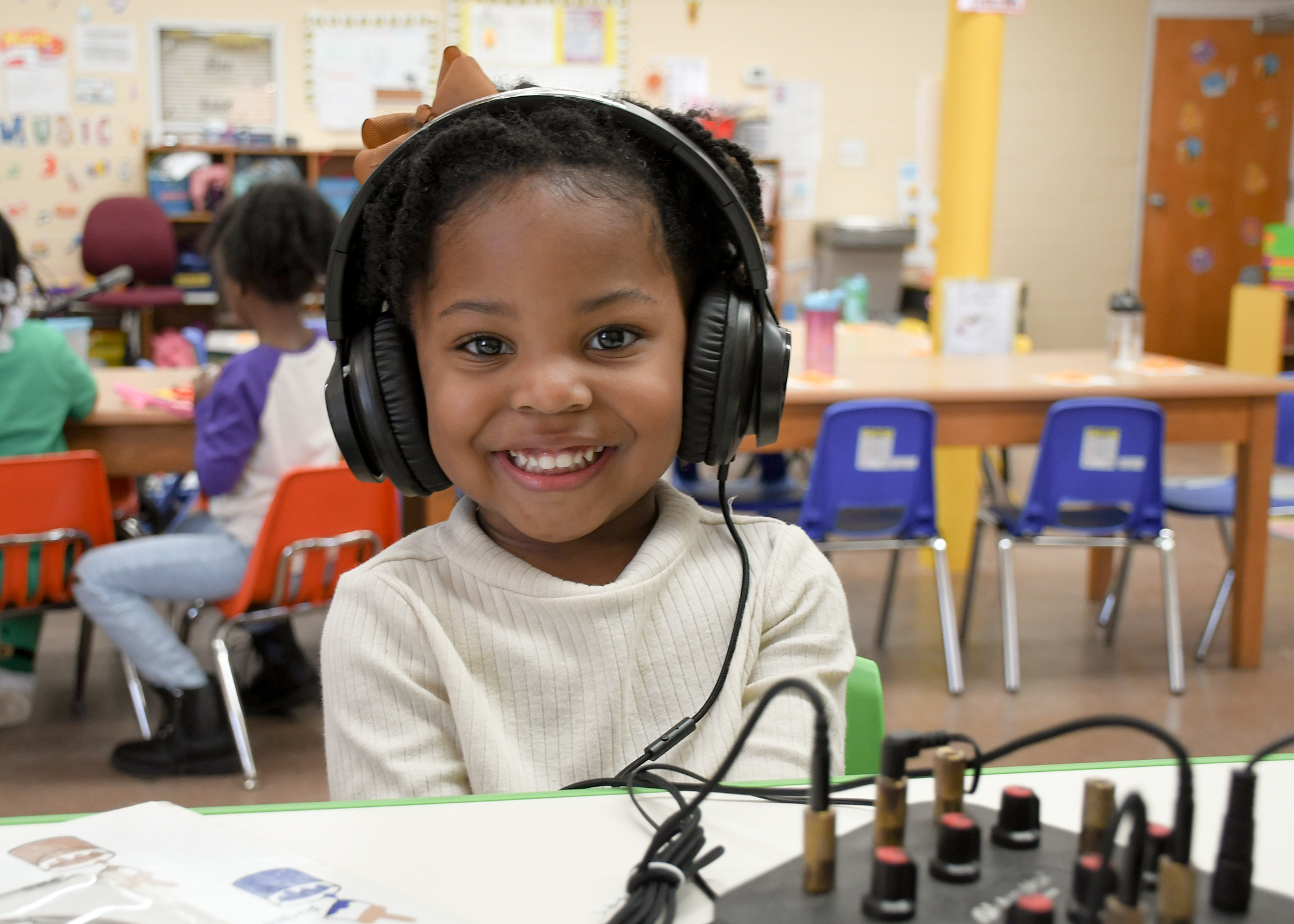 little girl with headphones learning at daycare